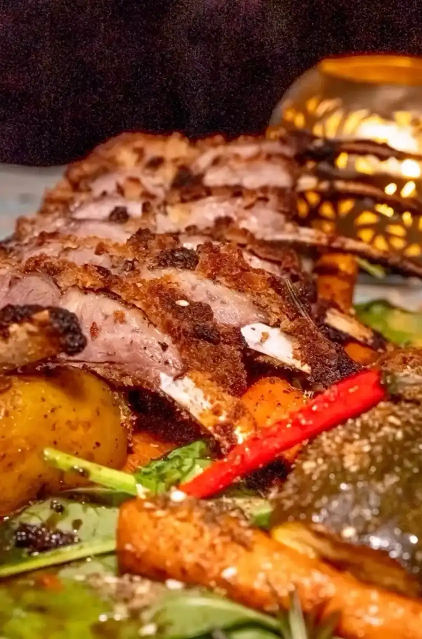 Slow-roasted halal lamb rack over spiced potatoes and vegetables at Moltaqa Yaletown